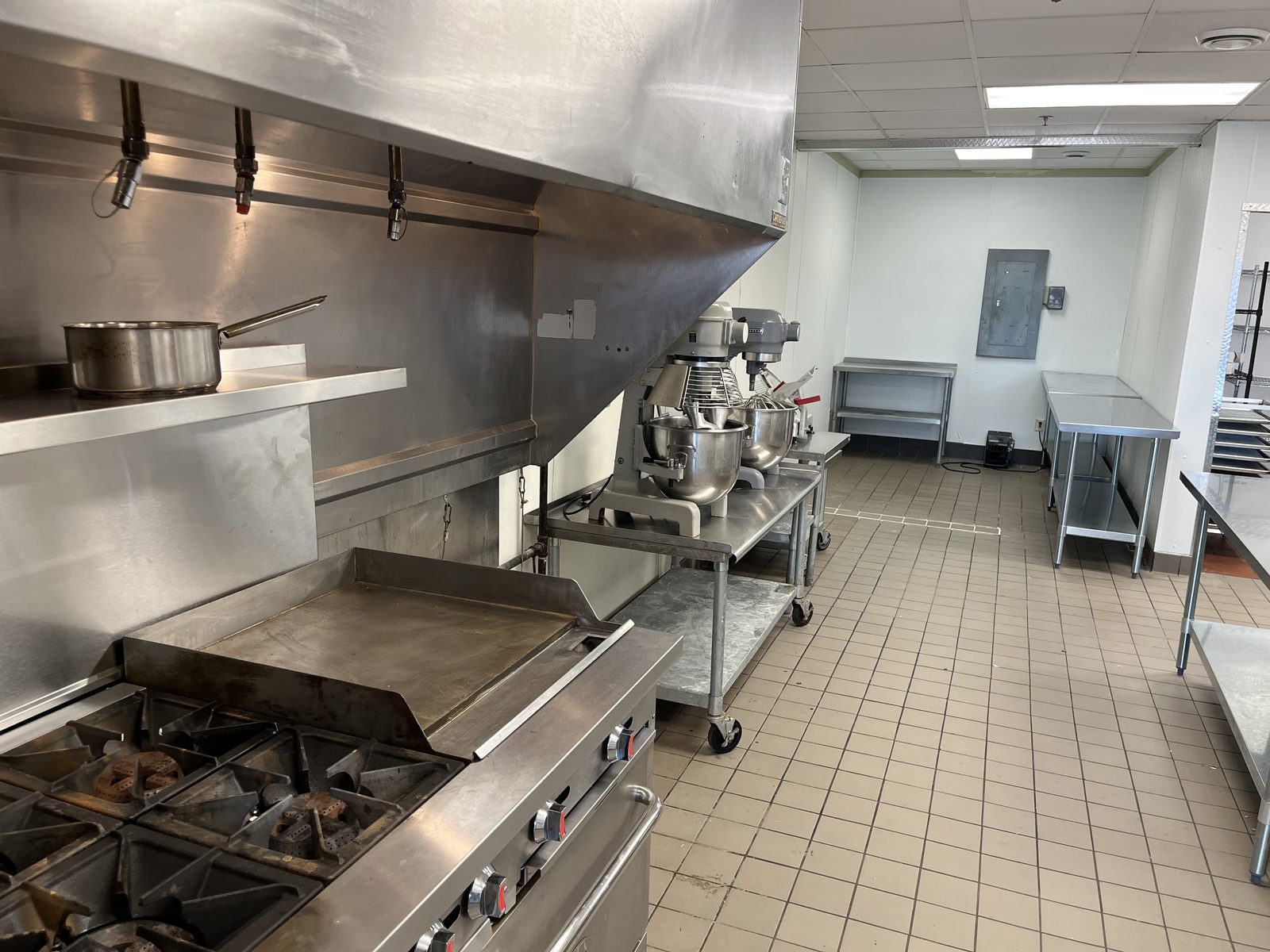 Christine's Commissary Kitchen — gas range, griddle, and commercial mixers along the line