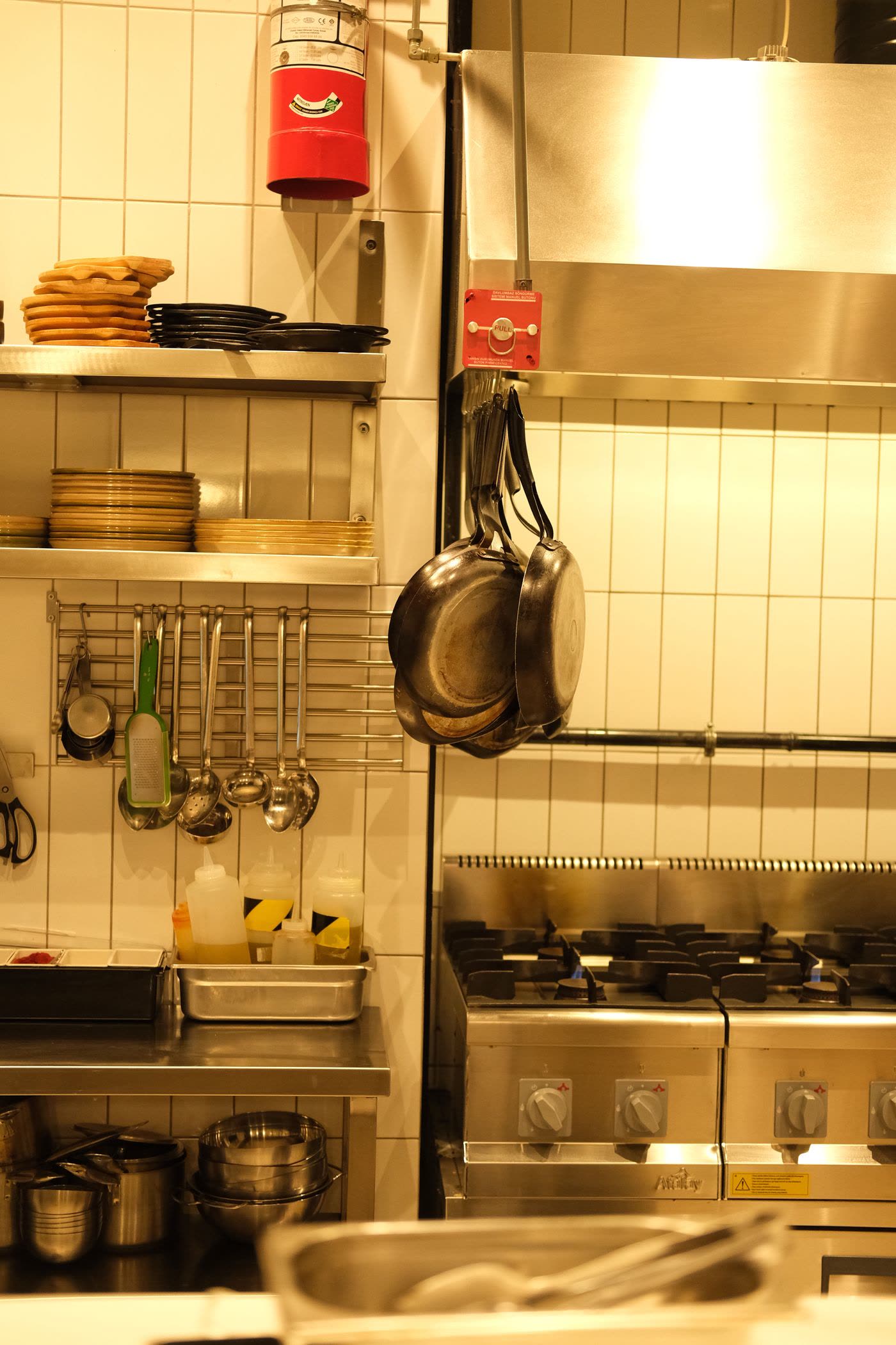 Gas range and hanging pans in a fully equipped kitchen