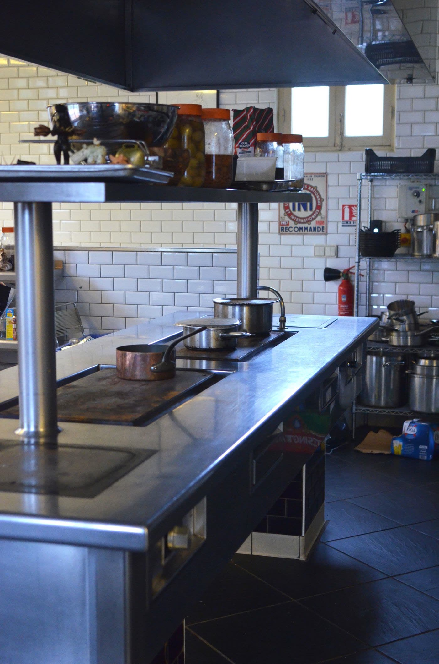 Stainless steel prep line along a subway-tiled wall