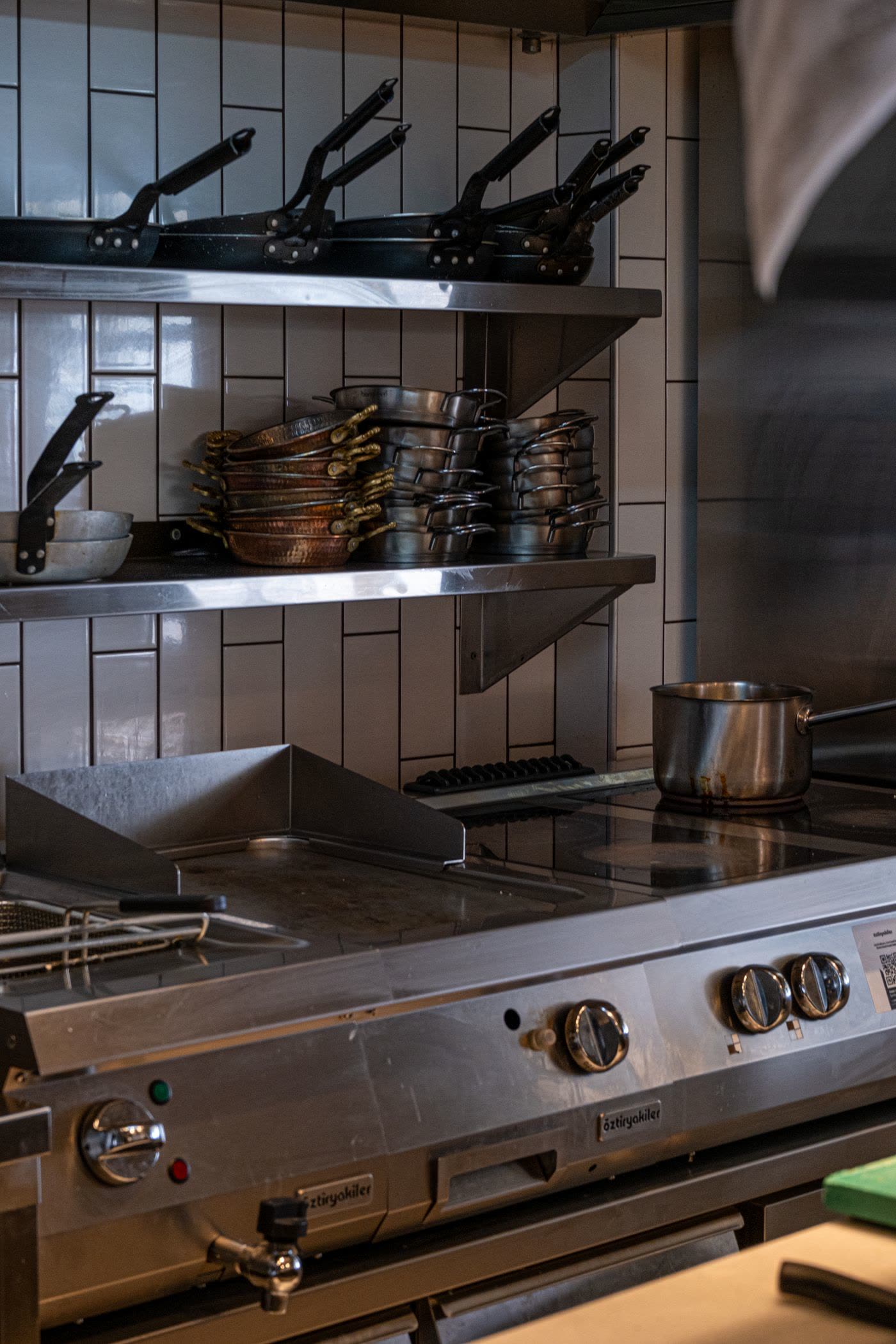 Commercial range with copper and steel pans on the shelves above